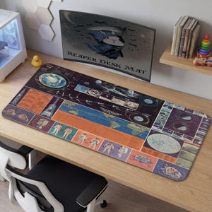 Puede incluir: Una alfombrilla de escritorio rectangular con un diseño vintage de exploración espacial. La alfombrilla presenta un mapa detallado de la Tierra, ilustraciones de astronautas y cuerpos celestes. El texto "REAPER DESK MAT" es visible en el monitor en el fondo.