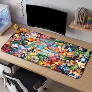 May include: A rectangular desk mat featuring a colorful collage of various cartoon characters. The mat is covered in a vibrant assortment of creatures in shades of blue, green, orange, and yellow. The mat is placed on a wooden desk.