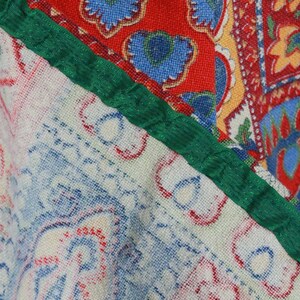 K&ouml;nnte beinhalten: Nahaufnahme eines Stoffes mit Patchwork-Muster. Der Stoff zeigt eine Vielzahl von Farben und Mustern, darunter Rot, Blau, Gr&uuml;n und Wei&szlig;. Der Stoff ist aus einem weichen, gewebten Material.