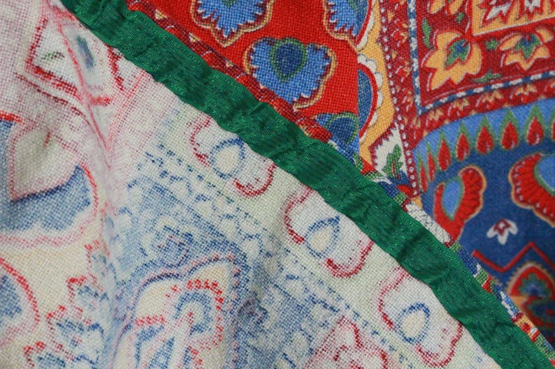 K&ouml;nnte beinhalten: Nahaufnahme eines Stoffes mit Patchwork-Muster. Der Stoff zeigt eine Vielzahl von Farben und Mustern, darunter Rot, Blau, Gr&uuml;n und Wei&szlig;. Der Stoff ist aus einem weichen, gewebten Material.