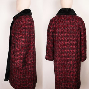 May include: A red and black tweed coat with a black faux fur collar. The coat is long and has a fitted silhouette.