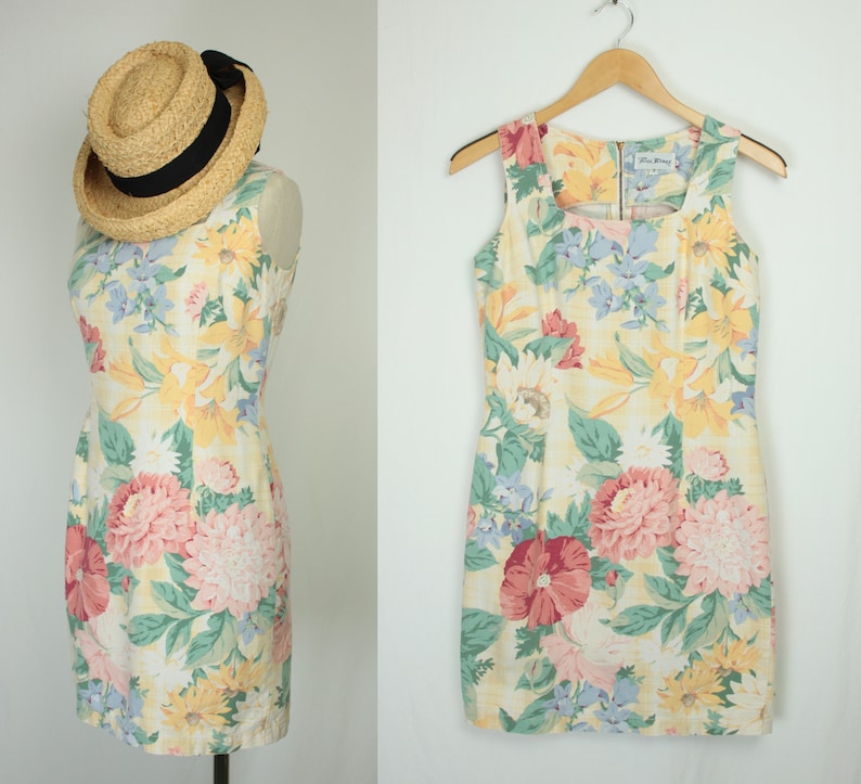 May include: A sleeveless floral print dress with a square neckline and a zipper closure in the back. The dress is made of a light-weight fabric and has a fitted silhouette.