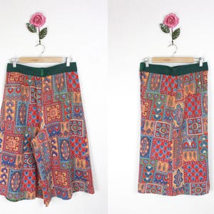 K&ouml;nnte beinhalten: Ein bunter, gemusterter Rock mit gr&uuml;nem Bund. Der Rock ist aus einem Patchwork-Stoff mit verschiedenen Rot-, Blau-, Gelb- und Gr&uuml;nt&ouml;nen gefertigt.