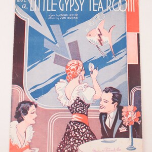 May include: A vintage sheet music cover for the song "In a Little Gypsy Tea Room." The cover features a colorful illustration of a woman in a red and black dress, a man in a suit, and a fish swimming in a blue and white background. The text "In a Little Gypsy Tea Room" is printed in black and white letters.