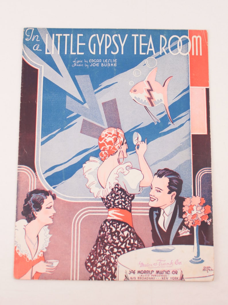 May include: A vintage sheet music cover for the song "In a Little Gypsy Tea Room." The cover features a colorful illustration of a woman in a red and black dress, a man in a suit, and a fish swimming in a blue and white background. The text "In a Little Gypsy Tea Room" is printed in black and white letters.