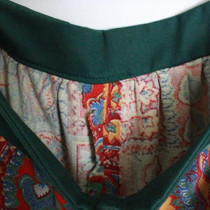K&ouml;nnte beinhalten: Ein gr&uuml;n-roter gemusterter Rock mit gr&uuml;nem Bund. Der Rock hat ein Paisley-Muster.