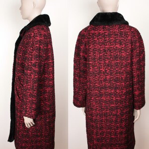 May include: A long red and black tweed coat with a black faux fur collar. The coat has a button closure and long sleeves.