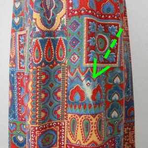 K&ouml;nnte beinhalten: Ein roter, blauer, gr&uuml;ner und gelber Patchwork-Stoff mit Paisley-Muster. Der Stoff hat verschiedene Designs und Formen.