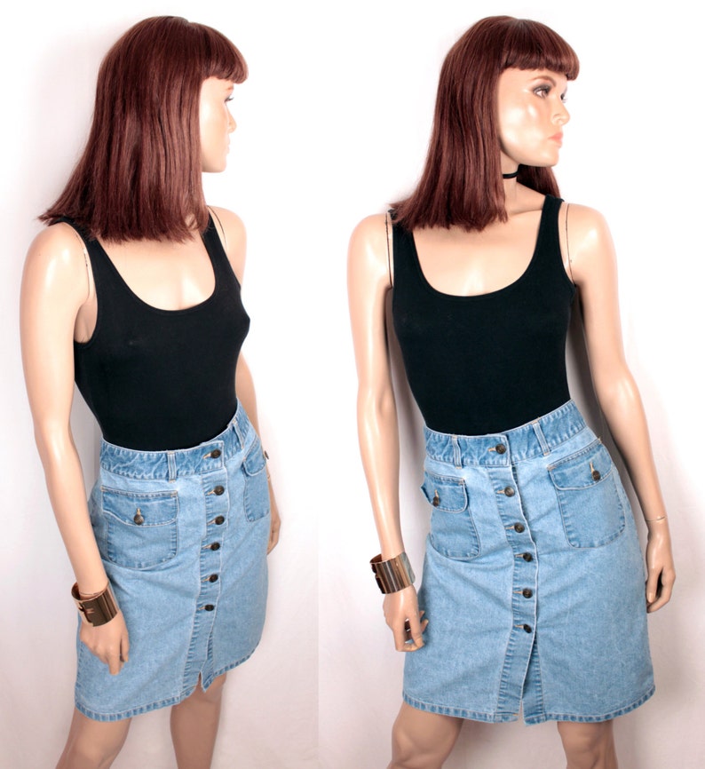 May include: A light blue denim skirt with a button front closure and two large pockets. The skirt is knee-length and has a straight silhouette.