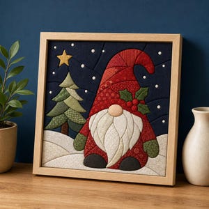 Puede incluir: Una pieza de arte mural de tela enmarcada que presenta un gnomo acolchado con un gorro rojo y bayas de acebo, junto a un árbol de Navidad verde estampado bajo un cielo nocturno azul oscuro con una estrella amarilla y puntos de nieve.