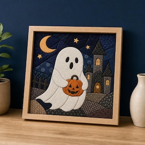 Puede incluir: Una pieza de arte mural de tela enmarcada de forma cuadrada que muestra un fantasma blanco sosteniendo una calabaza naranja. La escena incluye un cielo nocturno azul oscuro con una luna creciente amarilla, estrellas, un castillo gris y una valla.