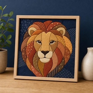 Può includere: Un'opera d'arte in tessuto incorniciata di forma quadrata che raffigura una testa di leone stilizzata. Il leone è composto da vari pezzi di tessuto nei toni dell'arancione, marrone e oro, su uno sfondo blu scuro con motivi geometrici.