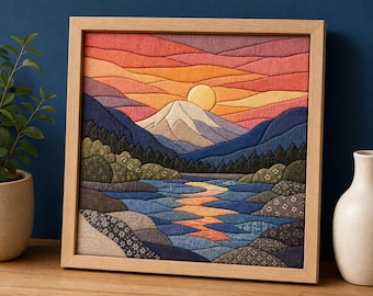 May include: A square fabric wall art piece in a light wood frame depicting a landscape with a mountain, a setting sun, and a river. The scene uses layered fabric patches in shades of orange, red, blue, and green, featuring floral patterns.