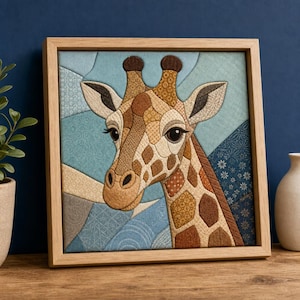 Op de afbeelding: Een vierkant ingelijst textielkunstwerk met een giraffekop samengesteld uit diverse patronen en gestructureerde stoffen in bruin-, beige- en crèmetinten, geplaatst tegen een geometrische achtergrond van blauwe en grijze stoffen segmenten.