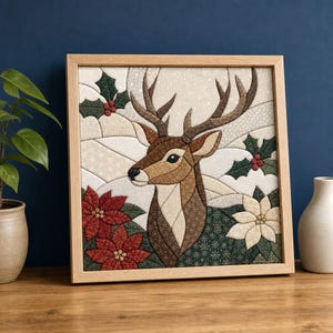 Può includere: Un'opera d'arte in tessuto incorniciata di forma quadrata che presenta un design patchwork di una testa di cervo marrone su uno sfondo innevato. La composizione include fiori di poinsettia rossi e bianchi, foglie di agrifoglio verdi e fiocchi di neve.