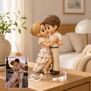 May include: A custom figurine of a couple dancing, featuring a person in a floral tiered dress and a person in a white polo shirt and beige trousers. The figurine stands on a clear circular base, inspired by a photograph of a couple in Paris.