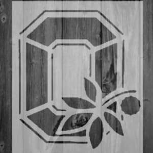May include: A stencil design featuring a geometric gemstone shape with a floral sprig. The stencil is white and appears on a wooden background. The gemstone has a multi-faceted design.