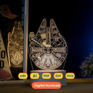 Puede incluir: Lámpara acrílica iluminada con forma de Halcón Milenario, con un diseño grabado detallado. La lámpara tiene una base gris. La imagen también incluye las palabras "cdr", "Ai", "PDF", "Dxf", "SVG" y "Digital Download".