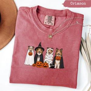 Crimson Comfort Colors shirt featuring four dogs in Halloween costumes.