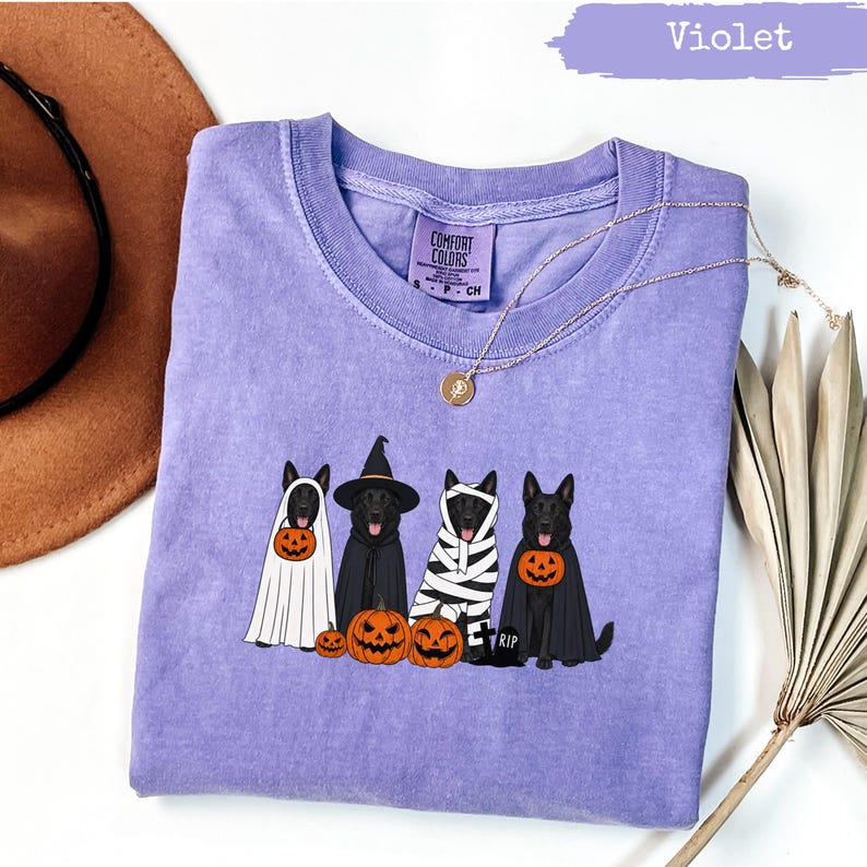 Violet t-shirt with four dogs in Halloween costumes and pumpkins.