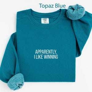 Apparently I Like Winning Topaz Blue Sweatshirt, Motivational Quote Shirt, Inspirational Graphic Tee, Uplifting Casual Wear, Cozy Pullover