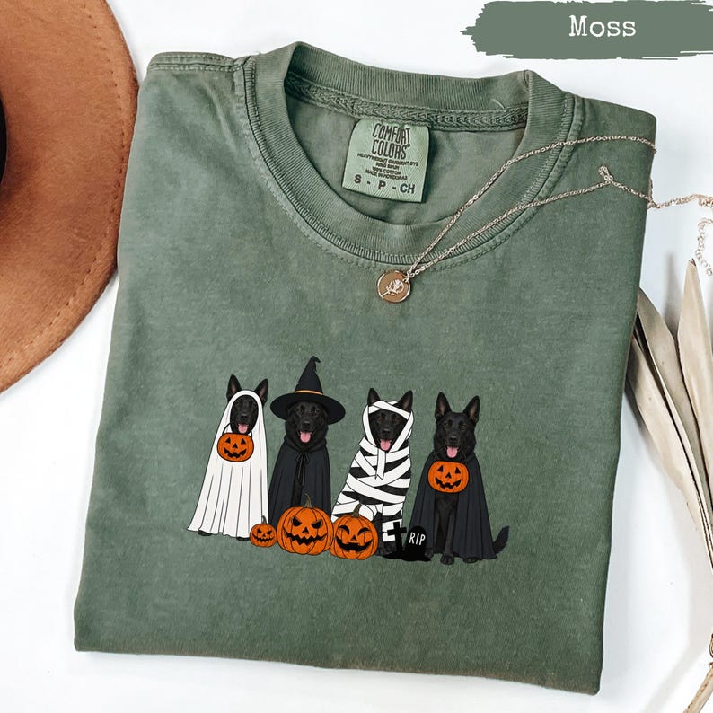 Green t-shirt with four black dogs in Halloween costumes and pumpkins.