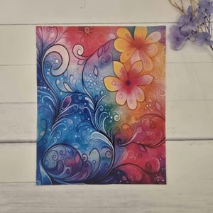 May include: A vibrant watercolor print featuring a floral design with swirling vines and two large flowers. The artwork showcases a gradient of colors, including blue, pink, orange, and yellow, creating a whimsical and artistic aesthetic.