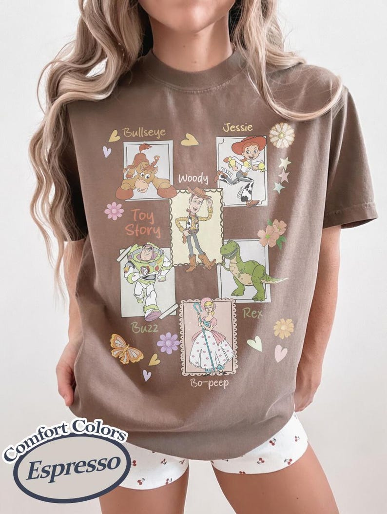 Puede incluir: Camiseta marr&oacute;n con un dise&ntilde;o de los personajes de Toy Story: Bullseye, Woody, Jessie, Buzz, Rex y Bo-peep. La camiseta incluye el texto "Toy Story" y "Comfort Colors".
