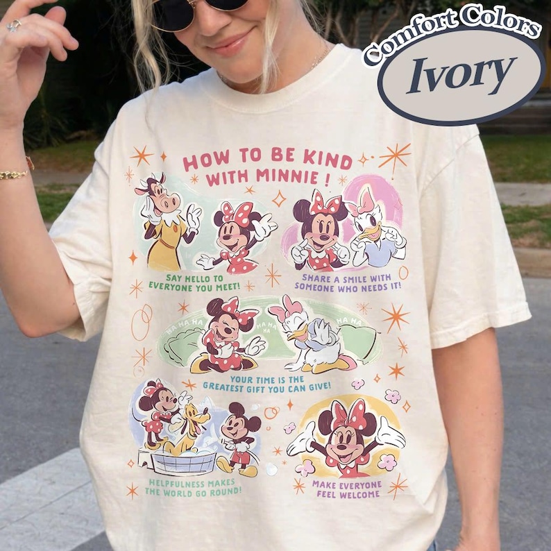 Puede incluir: Camiseta Comfort Colors color marfil con Minnie Mouse y sus amigos. La camiseta tiene el texto "HOW TO BE KIND WITH MINNIE!" y varios consejos de amabilidad. El gr&aacute;fico incluye im&aacute;genes de dibujos animados de Minnie, Daisy y otros personajes de Disney.
