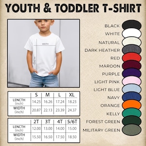 以下が含まれることがあります： サイズと色のオプションがある白い子供用Tシャツ。画像には、Tシャツを着ている子供が写っており、長さと幅の測定値はインチで表示されています。利用可能な色には、黒、白、ネイビーが含まれます。