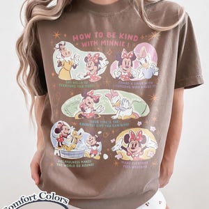 Puede incluir: Camiseta color espresso con un gr&aacute;fico de Minnie Mouse y sus amigos. La camiseta tiene el texto "HOW TO BE KIND WITH MINNIE!" y otras frases como "Say hello to everyone you meet!" y "Share a smile with someone who needs it!"