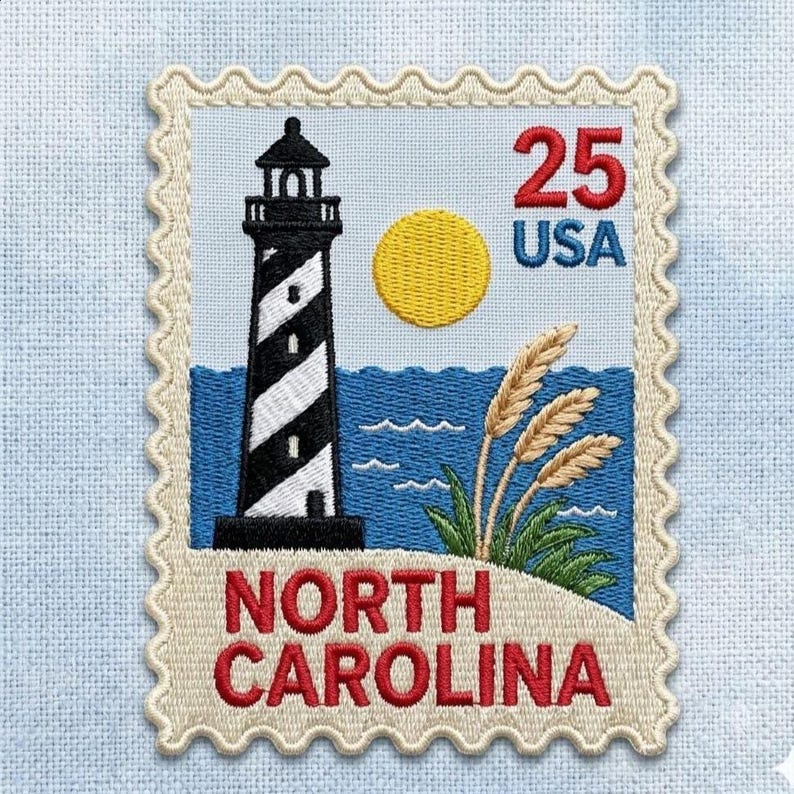 May include: A rectangular embroidered patch shaped like a postage stamp featuring a black and white striped lighthouse, a yellow sun, blue ocean waves, and green beach grass. The text reads 25 USA and NORTH CAROLINA in red and blue thread.
