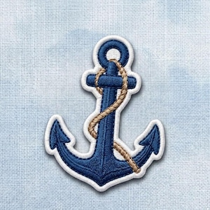May include: A navy blue embroidered anchor patch with a white border and a tan rope wrapped around the center shaft. The embroidery features dense stitching in a nautical shape, creating a textured appearance suitable for fabric application.