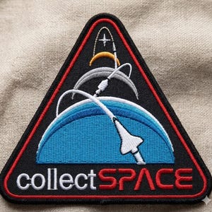 May include: Embroidered patch with a black triangular border and a red outline. The patch features a blue and white depiction of Earth, a white space shuttle, and the text "collectSPACE" in white and red.