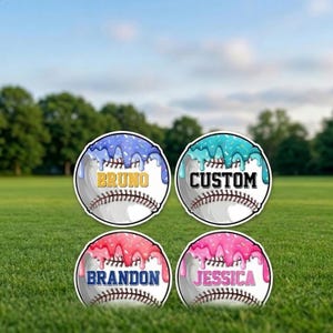 May include: Four baseball-shaped yard signs with a white baseball design and colorful frosting accents. Each sign has a different name: "Bruno", "Custom", "Brandon", and "Jessica". The signs are displayed on a green lawn with trees in the background.