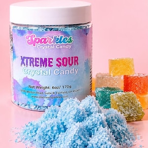 May include: A clear plastic jar with a white lid containing blue crystal candy. The label reads Sparkles Crystal Candy, XTREME SOUR Crystal Candy, Net Weight: 6oz/ 170g, 6106 Winton Road, Suite B, Fairfield, OH 45240, www.discoversparkles.com.