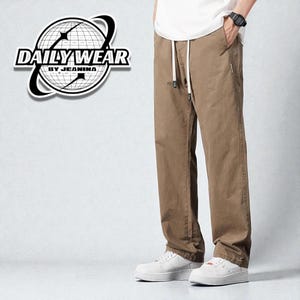 May include: Khaki-colored pants with a drawstring waist and white sneakers. The pants have a relaxed fit and side pockets. The image also features a logo that says "DAILY WEAR BY JEANINA".