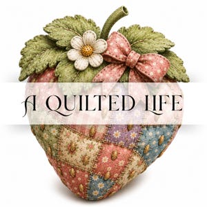 May include: A strawberry-shaped decorative object featuring a patchwork quilt pattern in shades of pink, blue, and cream with floral and polka dot prints. It is topped with green fabric leaves, a white flower, and a pink polka dot bow. Text reads A QUILTED LIFE.