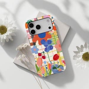May include: A smartphone case featuring a colourful grid pattern overlaid with illustrations of blue berries, red cherries, and various tulips in shades of pink, orange, and red. The design includes small heart shapes and abstract floral motifs.