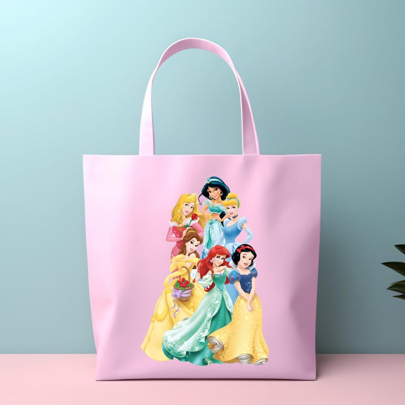 May include: Pink tote bag featuring a group of cartoon princesses. The princesses are depicted in their signature gowns and hairstyles. The bag has a matching pink handle and is made of a soft, durable material.