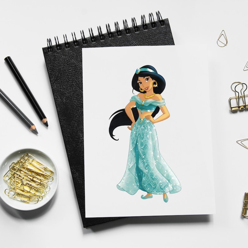 May include: A print of a cartoon character in a teal dress with gold jewelry and a blue headband. The character has long black hair and is standing on a white background. The print is on a white paper, resting on a black notebook.