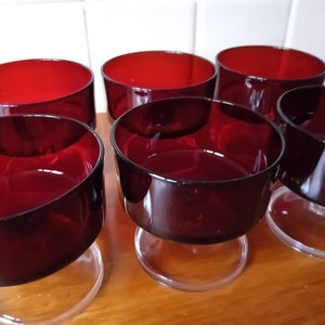 May include: Six clear glass dessert dishes with a deep red coloured bowl and a clear glass stem and base.