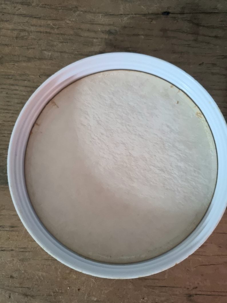 May include: White round lid with a slightly textured surface.