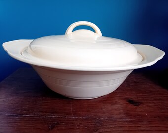 May include: A white ceramic serving bowl with a lid. The bowl has a fluted design and the lid has a handle.