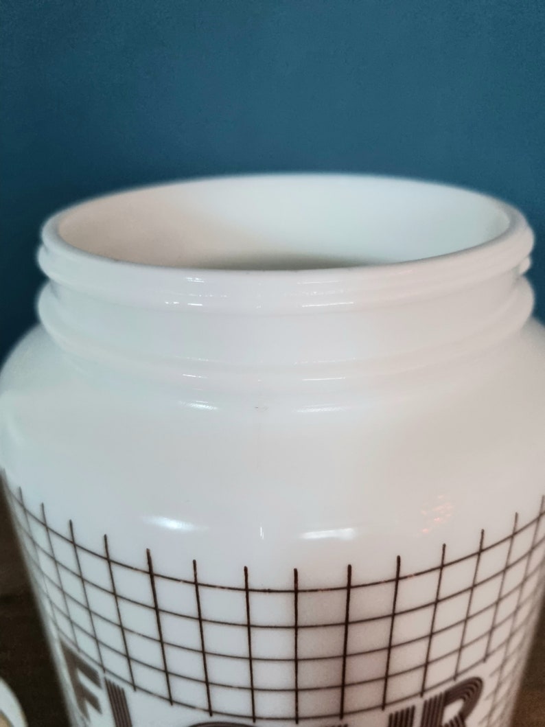 May include: White ceramic jar with a brown grid pattern and the word "Flour" printed on the front.
