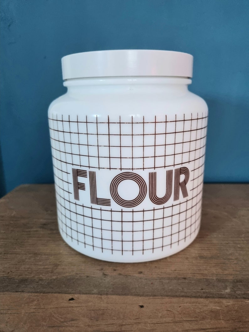 May include: White ceramic canister with a brown grid pattern and the word "FLOUR" in brown lettering.