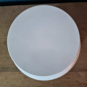 May include: A white ceramic pedestal cake stand with a smooth, round surface. The stand is perfect for displaying cakes, cupcakes, or other desserts.