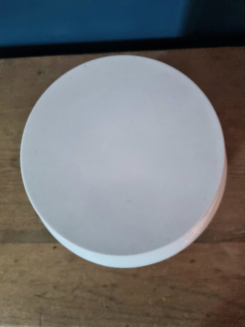 May include: A white ceramic pedestal cake stand with a smooth, round surface. The stand is perfect for displaying cakes, cupcakes, or other desserts.