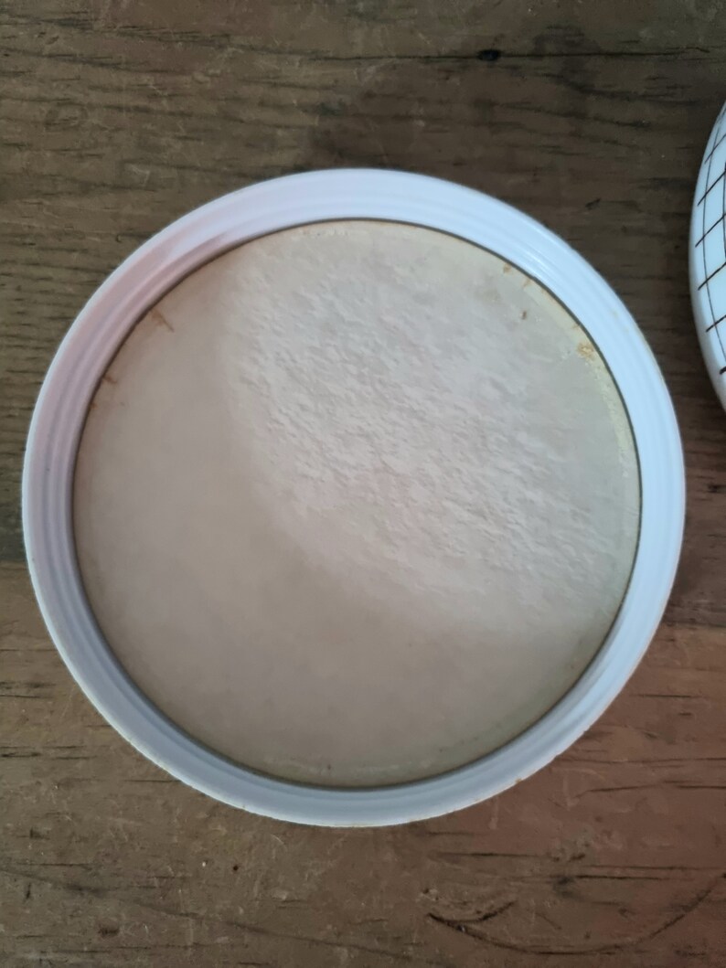 May include: White round lid with a smooth, slightly textured surface. The lid is made of plastic and has a raised edge.