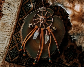 suncatcher in copper. a copper sun necklace inspired by a dreamcatcher adorned with clear quartz and brown leather.